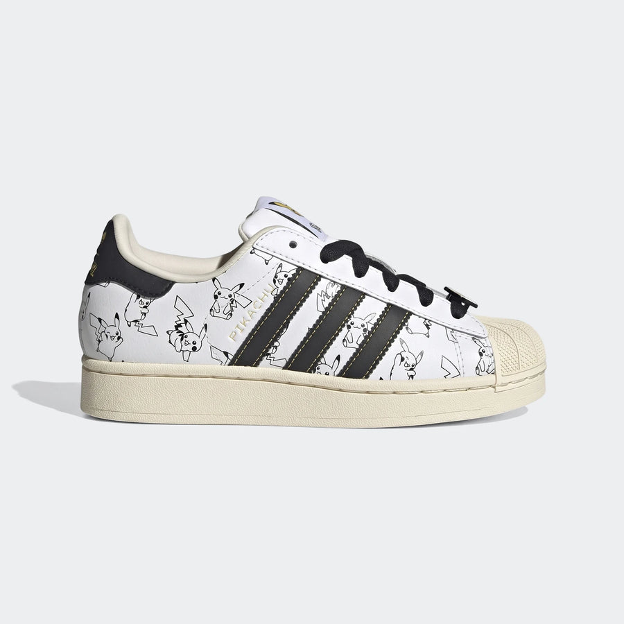 White Adidas Superstar II shoes with black three-stripes and all-over Pikachu outline graphics, featuring black laces and an