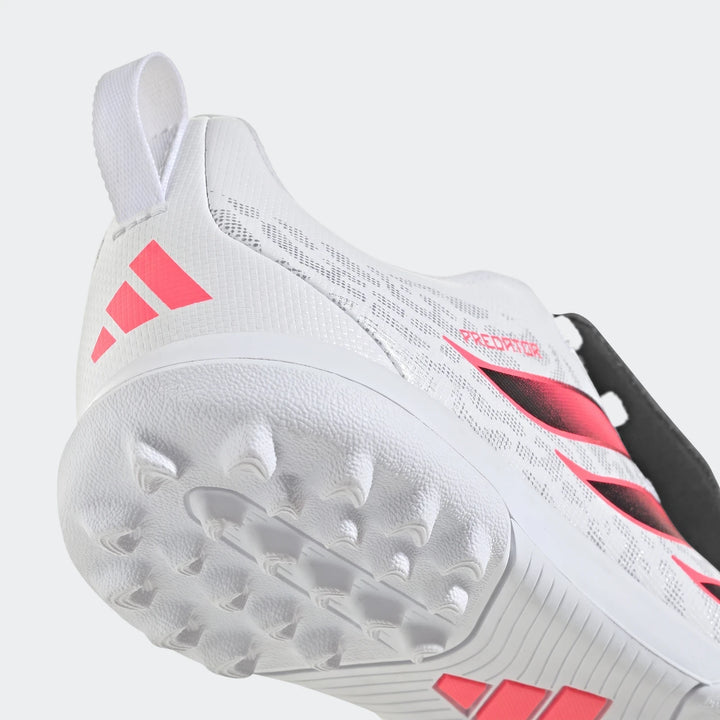 White Adidas Predator Club kids turf football boot featuring pink stripes, a studded sole, and a pull tab, shown from a