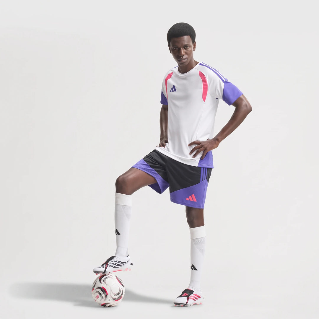 Male model wearing Predator Elite Fold-Over Tongue Firm Ground Football Boots with a white and purple football kit, foot