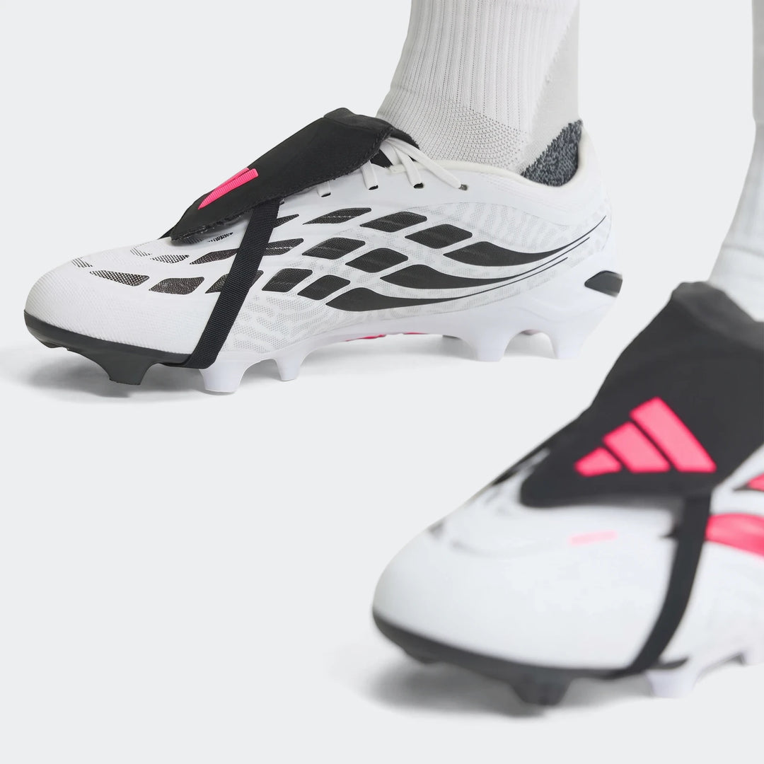 Close-up of white, black, and pink Predator League Fold-Over Tongue Firm Ground Football Boots with studded soles, worn by a