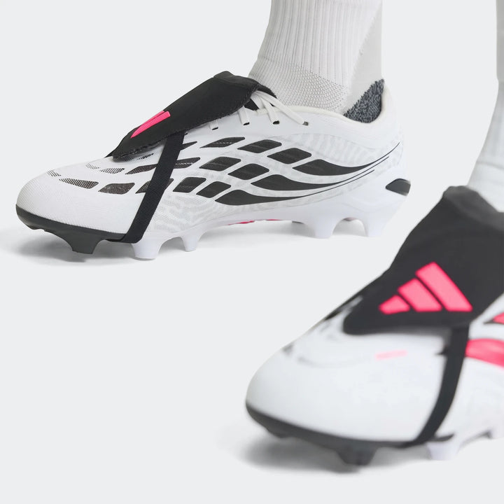 Close-up of white, black, and pink Predator League Fold-Over Tongue Firm Ground Football Boots with studded soles, worn by a