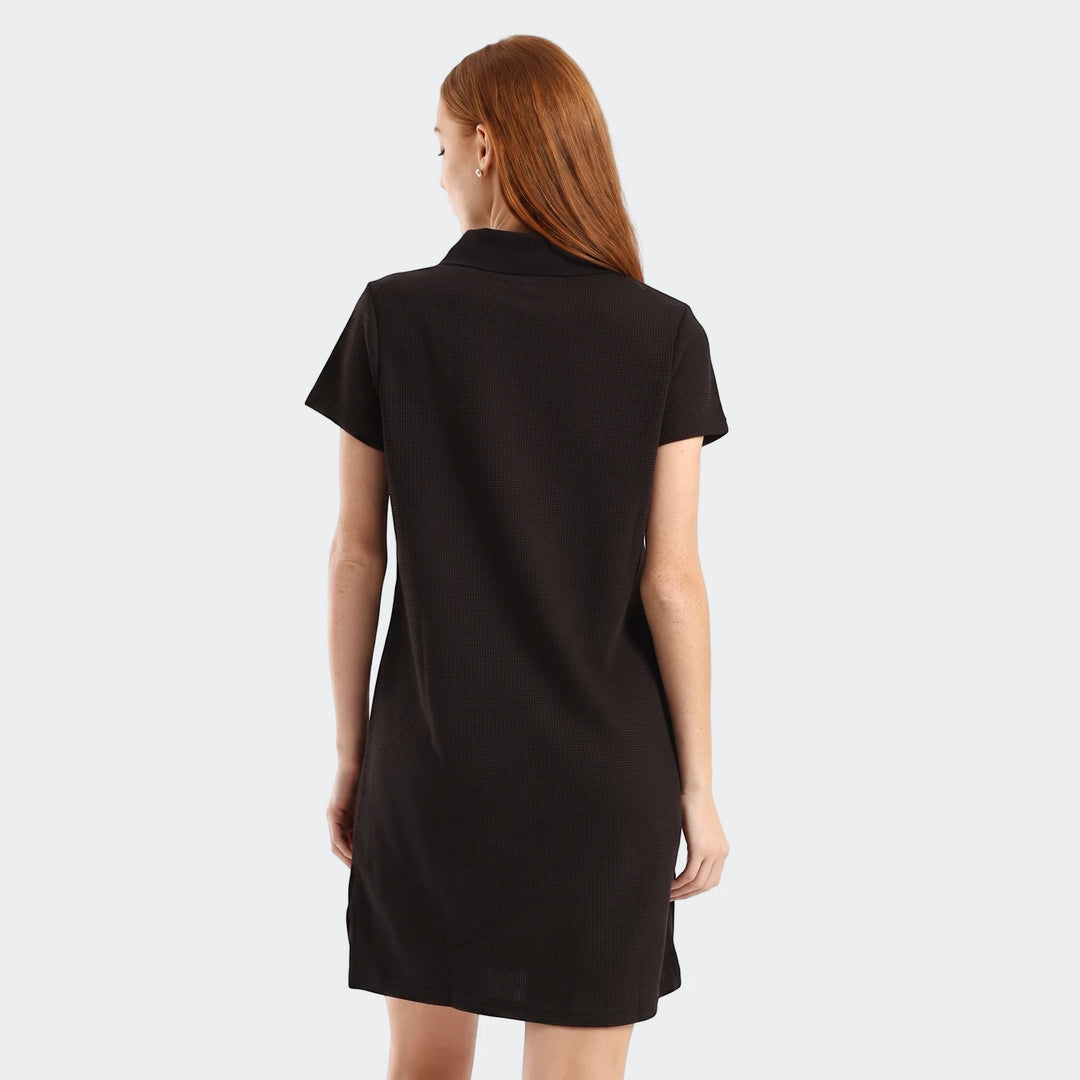 Black Puma Class Pinnacle Dress with short sleeves, featuring a woman from the back, highlighting the textured fabric.