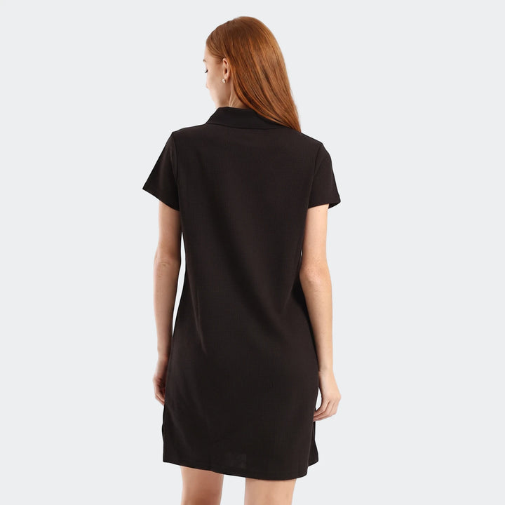 Black Puma Class Pinnacle Dress with short sleeves, featuring a woman from the back, highlighting the textured fabric.