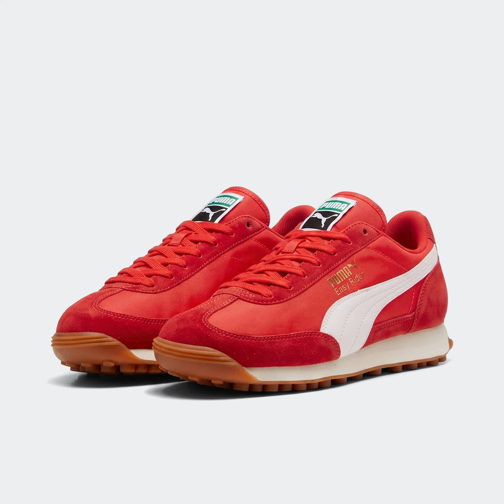 A pair of red Puma Easy Rider Kids Ps sneakers made of suede and textile, featuring a white formstrip and gum rubber sole,