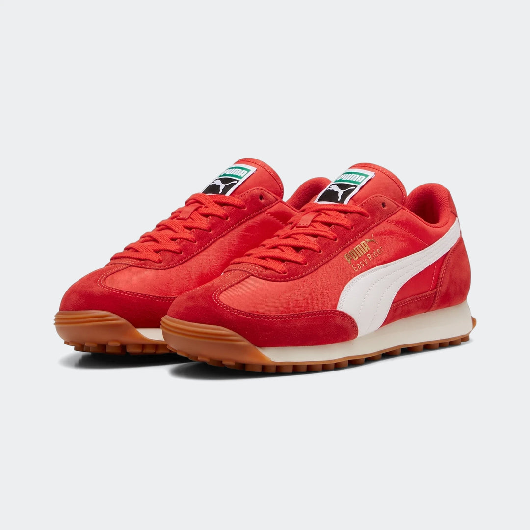 Pair of red Puma Easy Rider Vintage PS sneakers with white side stripes, red laces, and brown gum soles, presented from a