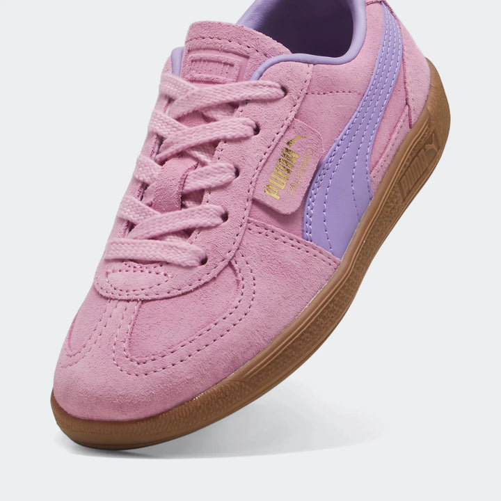 Pink suede Puma Palermo Ps children's sneaker with purple formstrip, brown gum sole, and matching laces, captured from a