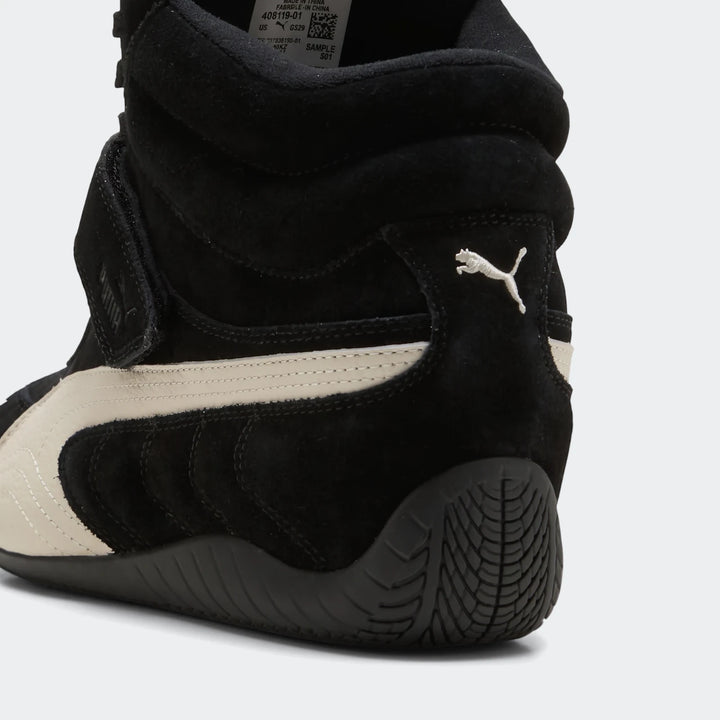 Close-up view of a black and off-white Puma Speedcat Wedge OG high-top women's sneaker made of suede and leather.