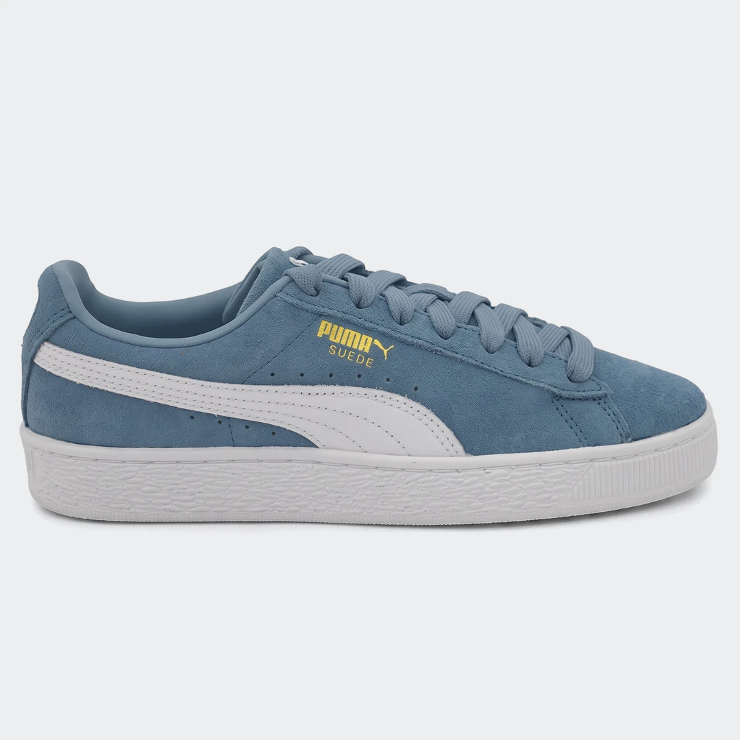 Side view of a blue Puma Suede Classic sneaker with white Formstrip, white laces, and a white rubber sole, resting on a