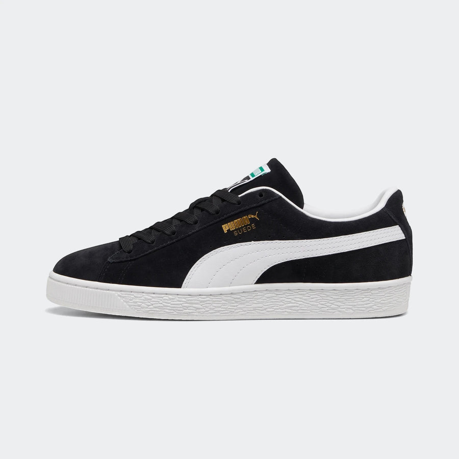 Puma Suede Classic unisex sneakers in black suede with white formstrip and sole, shown from the side.