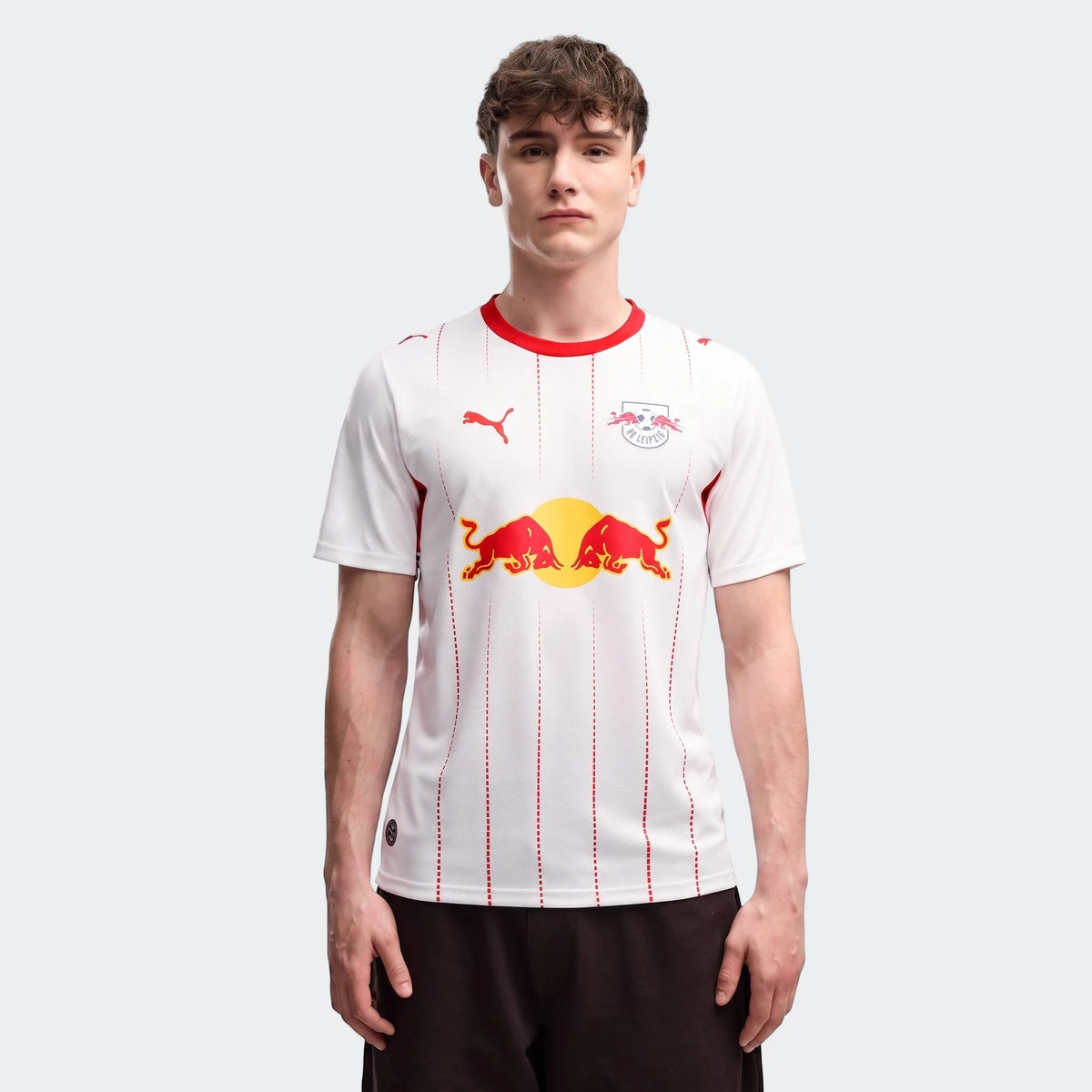 Men's Rb Leipzig 26/27 Home Jersey, white with red trim, Puma and Red Bull logos, modeled by a young man facing forward.