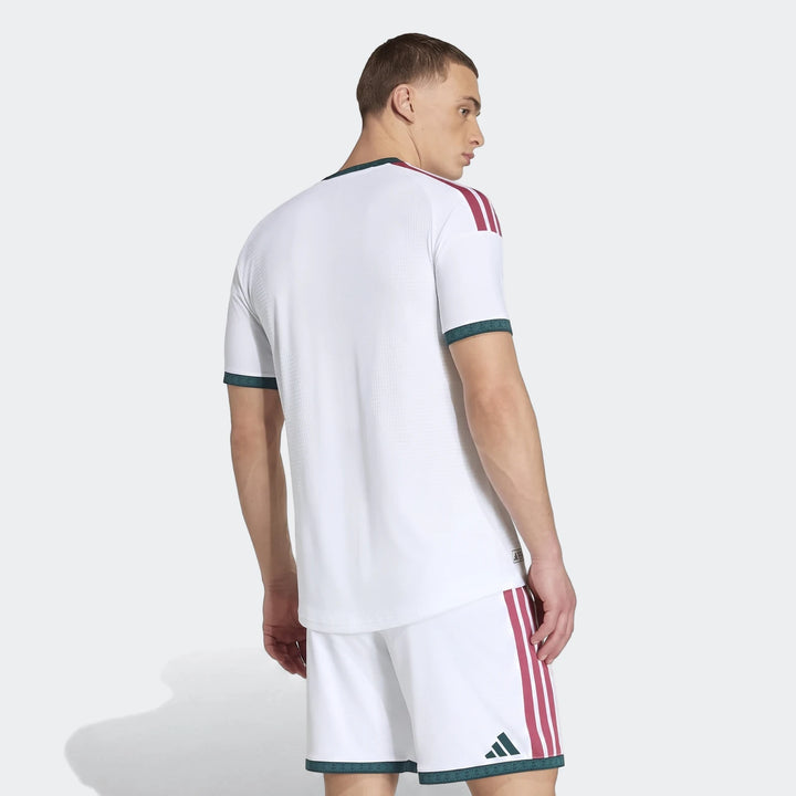 Men's white Real Madrid 25/26 Authentic Home Jersey and shorts, rear view. Features burgundy stripes and green trim.