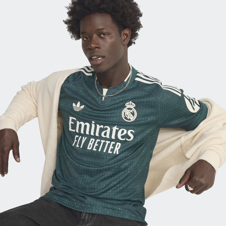 Dark green Real Madrid 26/27 Away Authentic Jersey with white Adidas stripes and Emirates sponsor, worn by model.