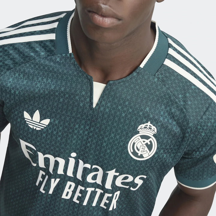 Real Madrid 26/27 Away Authentic Jersey worn by a model, featuring a dark green patterned fabric with white logos and