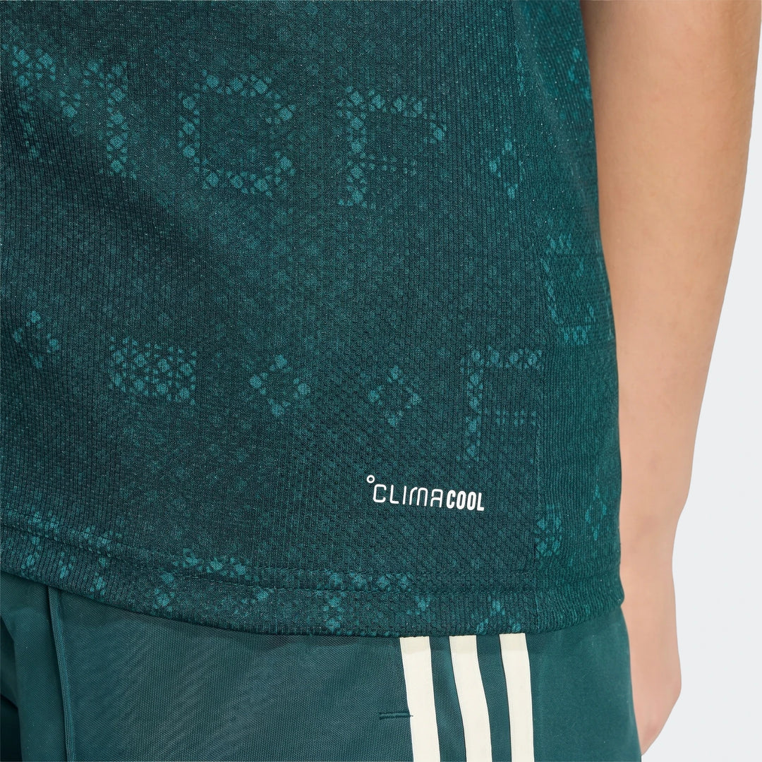 Kids' dark teal Real Madrid 26/27 Away Jersey with subtle pattern and white 'CLIMACOOL' logo, worn with matching shorts.