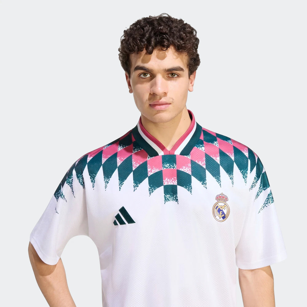 Male model wearing a white Real Madrid Street Jersey with pink and teal patterned shoulders, detailed with the club crest.