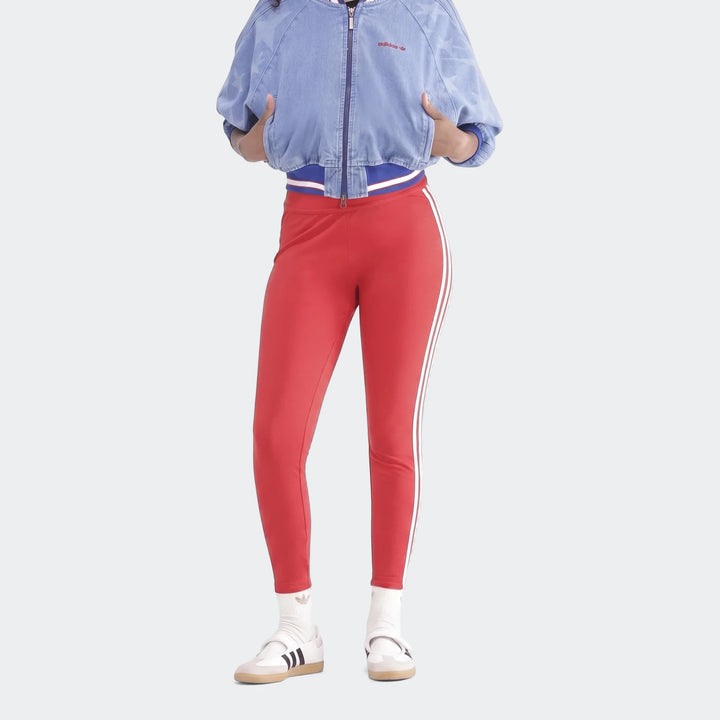 Person wearing red Adidas 3-Stripes Cotton Leggings with white side stripes, a blue denim bomber jacket, and white sneakers.