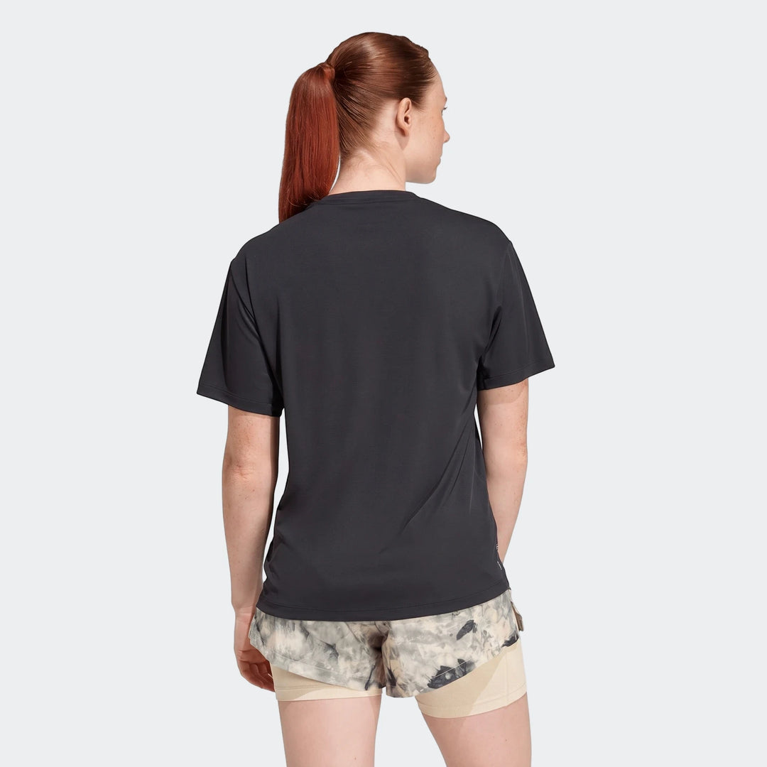 Woman from behind wearing a black short-sleeve Run Essentials T-Shirt and patterned athletic shorts.