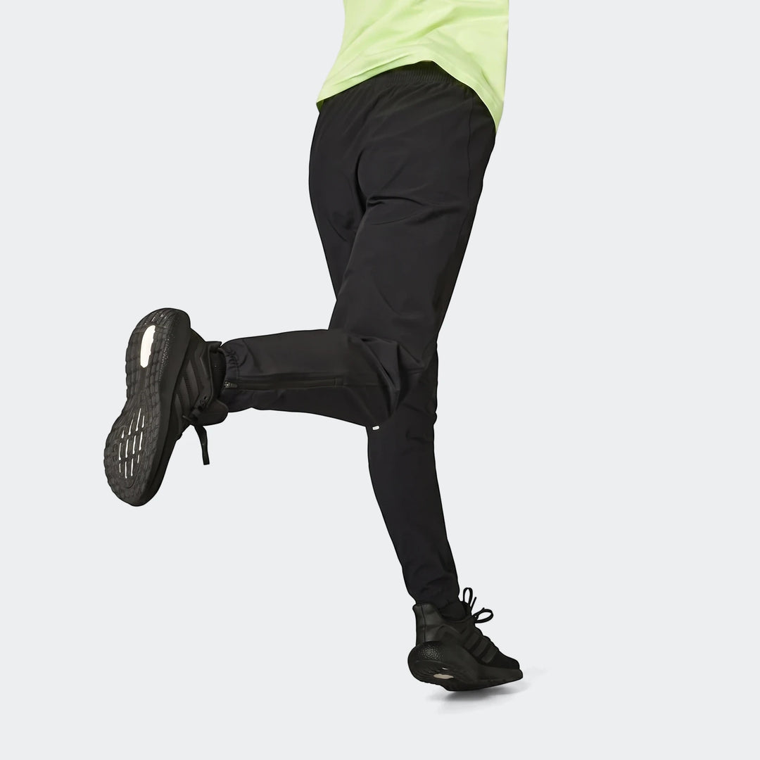 Black Run It Tko Joggers worn by a person in an active pose, paired with black running shoes, showcasing the side profile