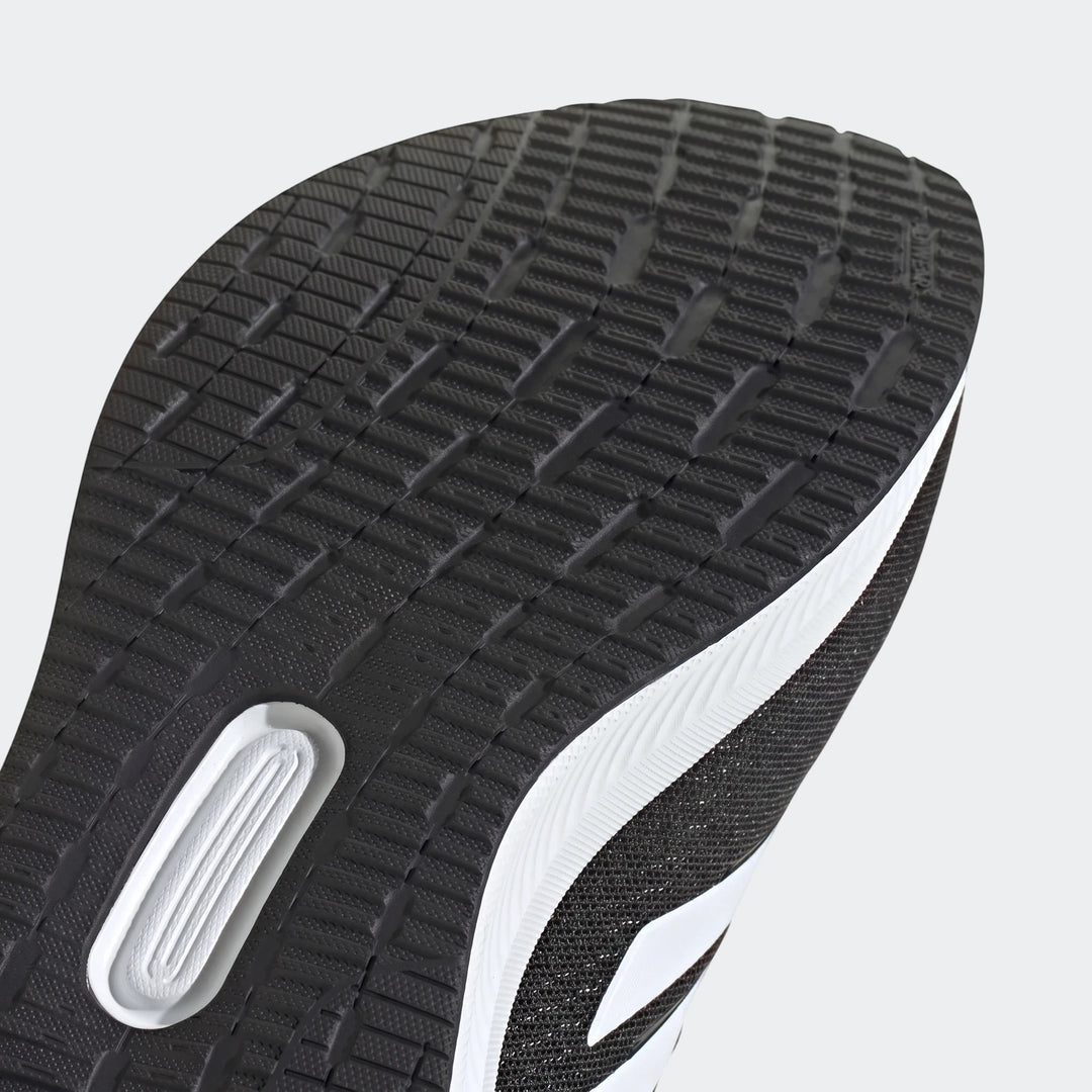 Close-up view of a Runfalcon 5 Black Sneaker sole, showcasing its black rubber tread pattern and crisp white midsole details.