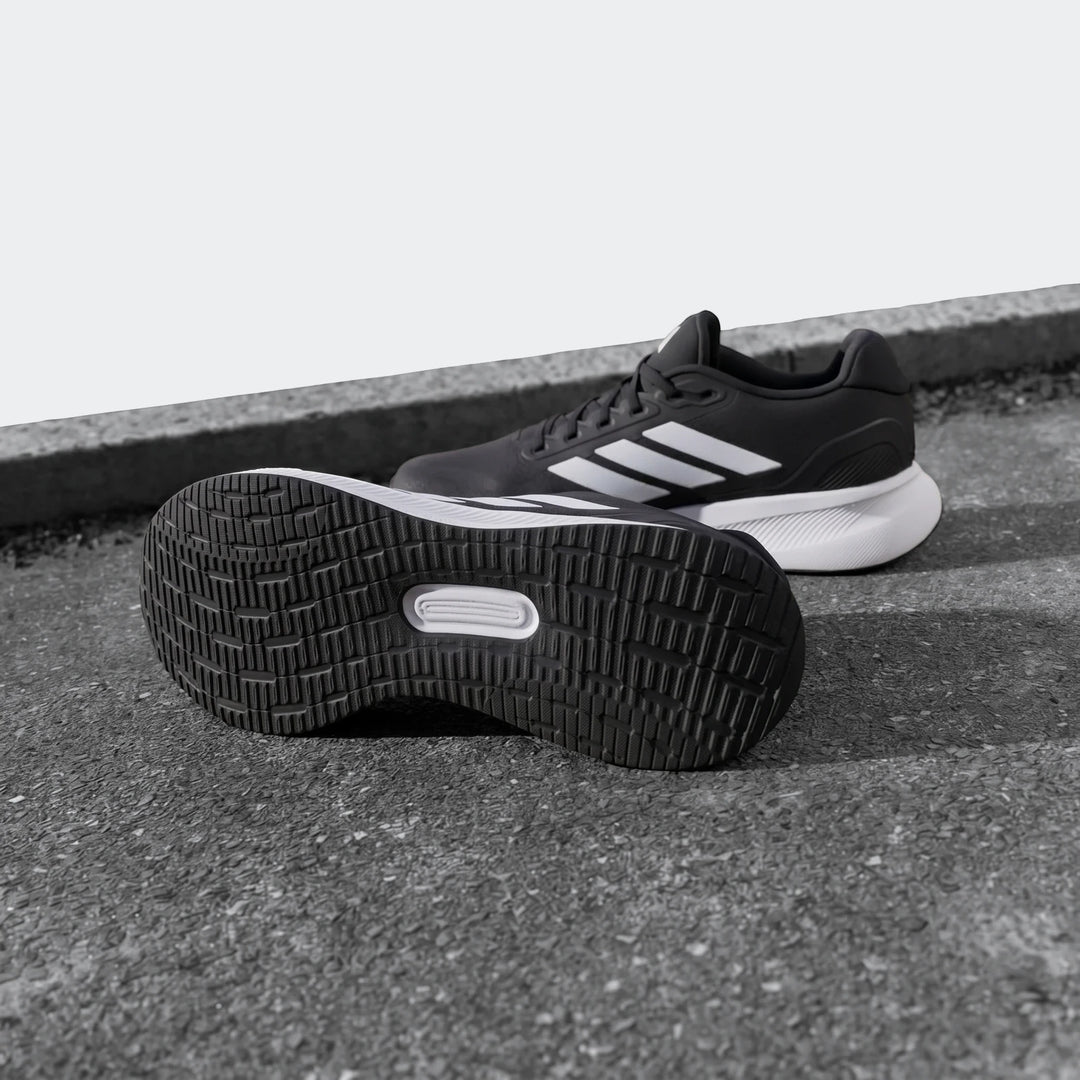 Runfalcon 5 Black Sneakers with white stripes and visible sole detail, positioned on a ground surface, ideal for running.