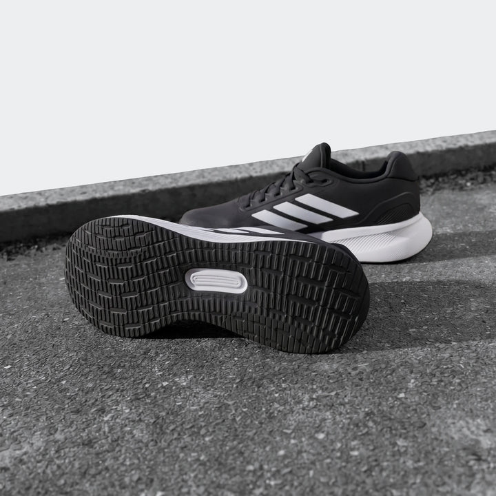 Runfalcon 5 Black Sneakers with white stripes and visible sole detail, positioned on a ground surface, ideal for running.