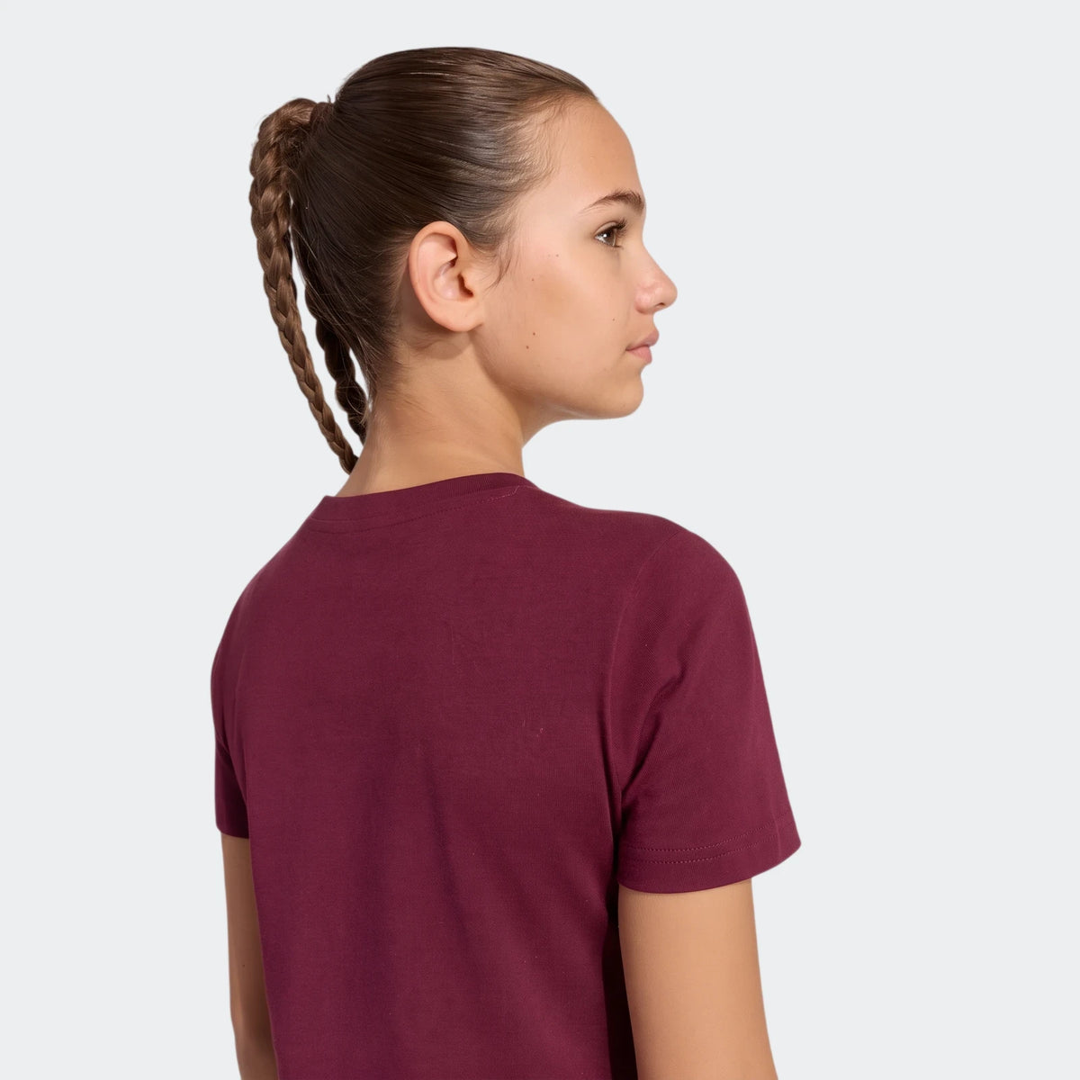 Young girl wearing a maroon Satin T-Shirt, depicted in profile view with braided hair, on a clean white background.