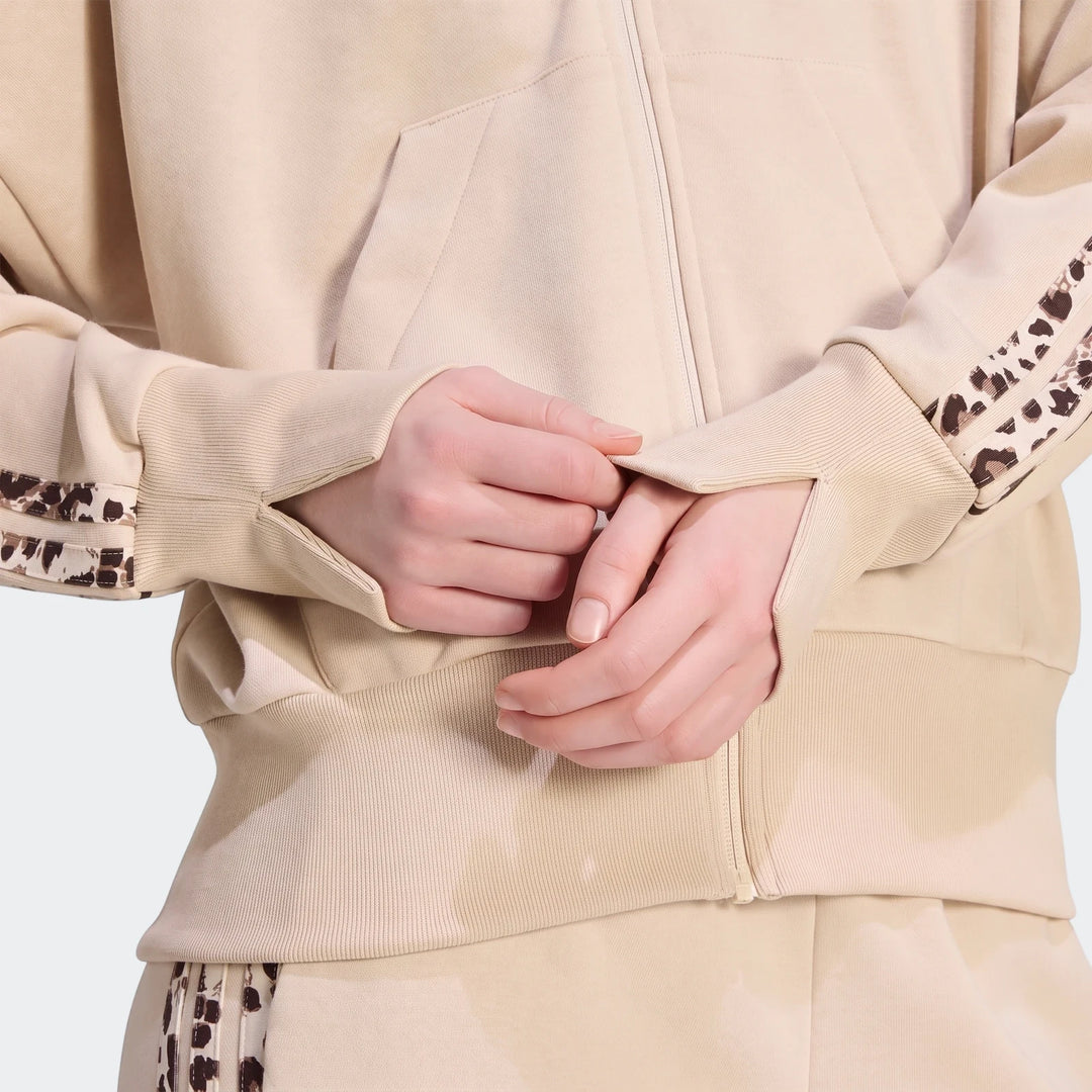 Close-up of a person wearing a beige Seasonal Essentials Animal Print 3-Stripes Full-Zip Hooded Track Top, highlighting the