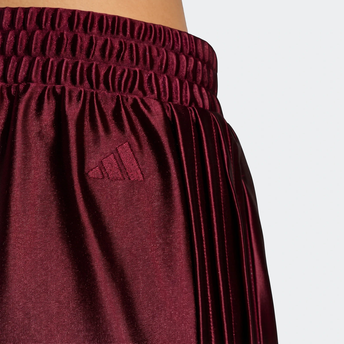 Close-up of maroon Seasonal Essentials Satin Tracksuit Bottoms, featuring a ruched elastic waistband, pleats, and an Adidas