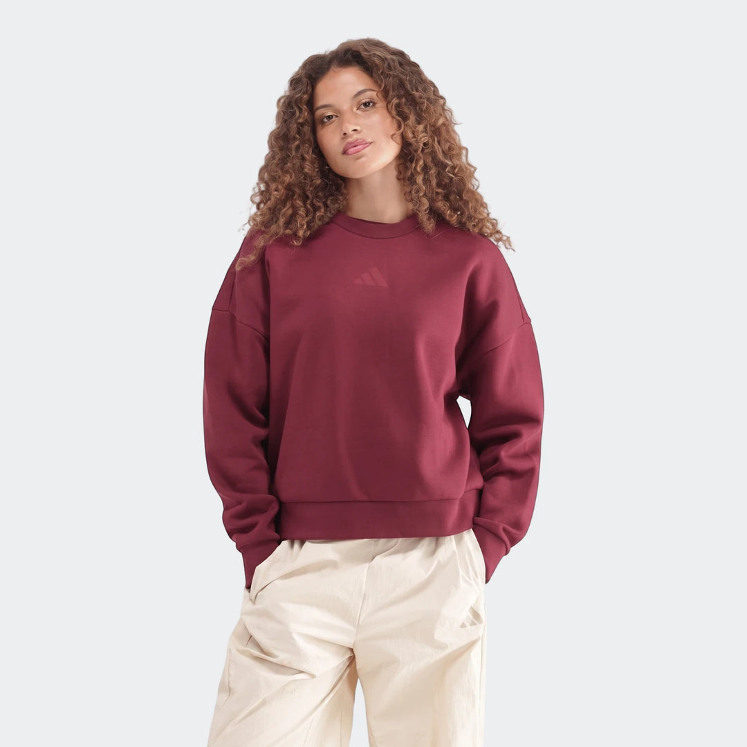 Maroon Slim Fleece Crew Sweatshirt worn by a woman, paired with cream-colored track pants, studio shot.
