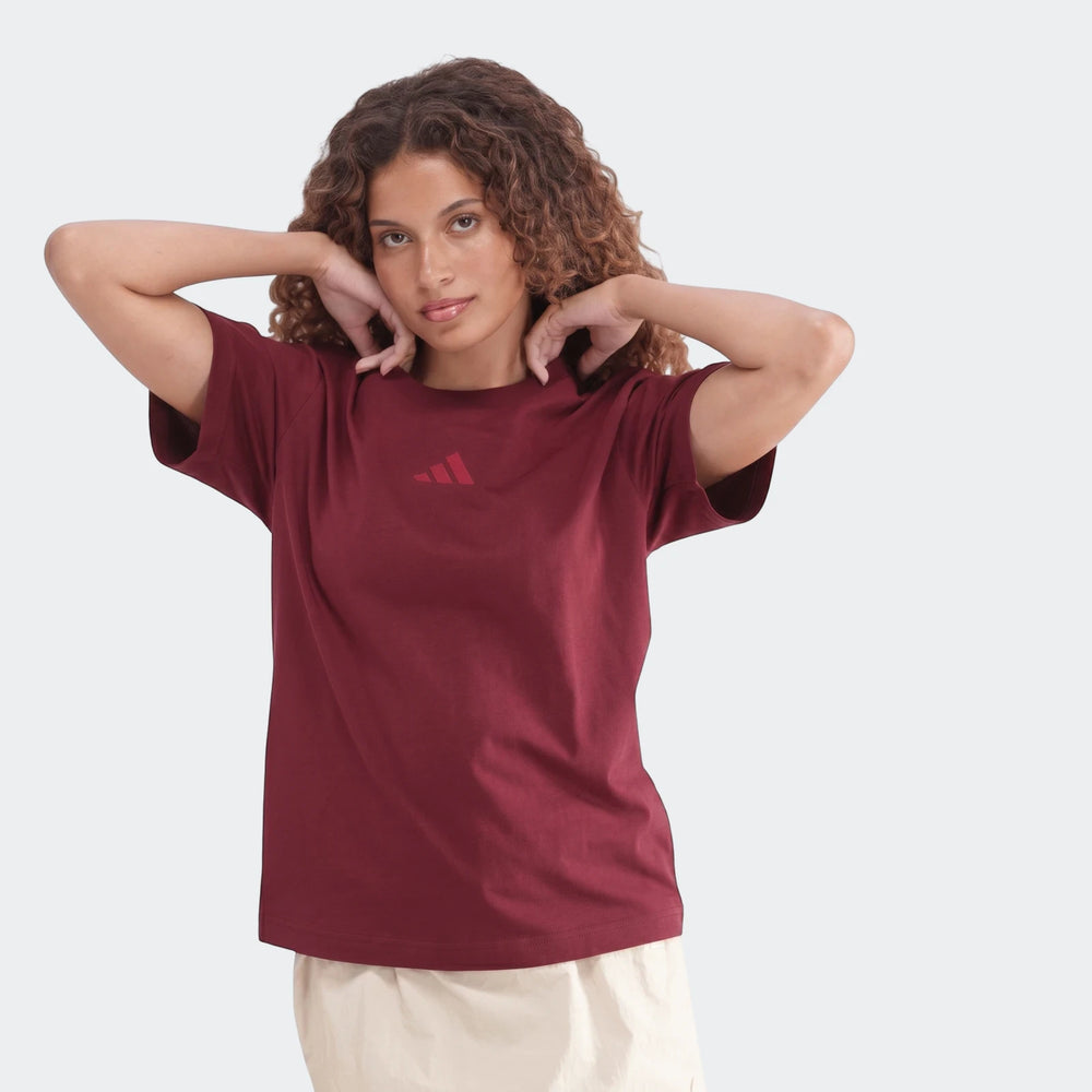 Maroon Slim Single Jersey T-Shirt on a young woman with curly hair, posing with hands near her head, studio shot.