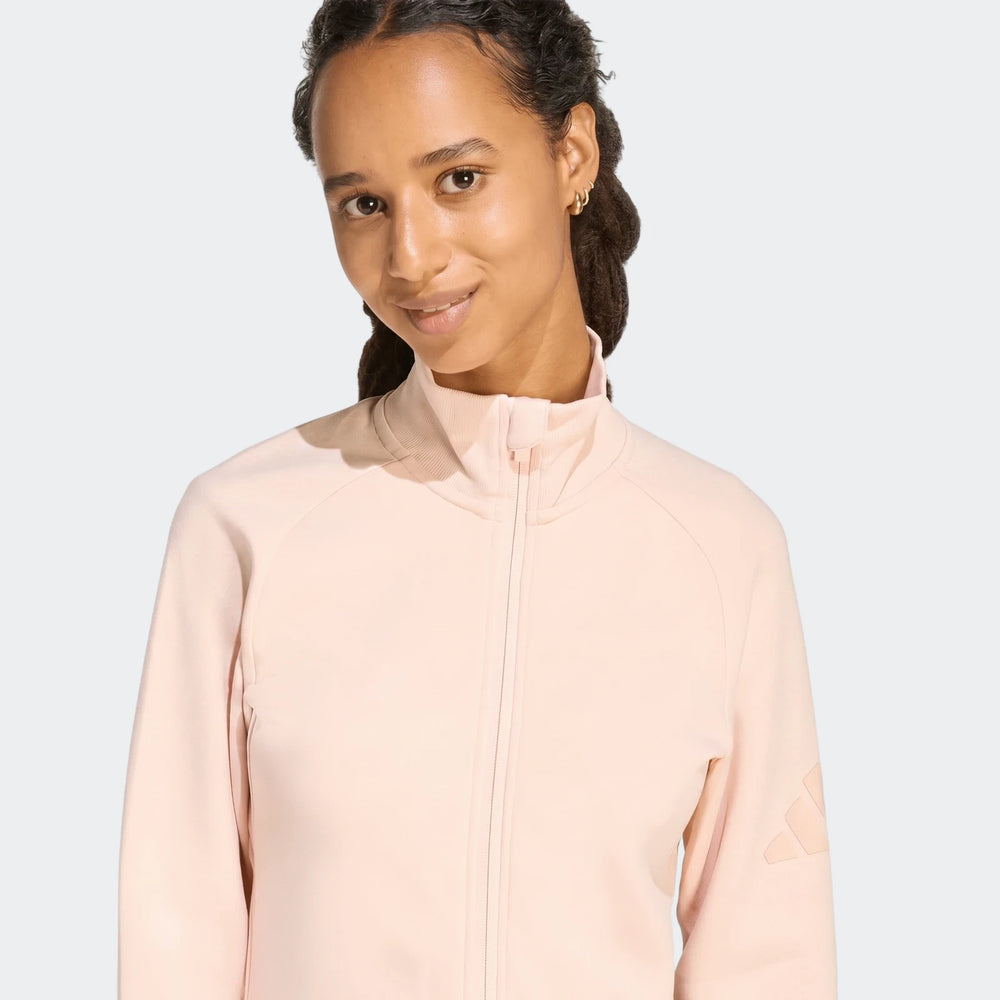 Woman smiling in a light pink Soft Luxe Slim Track Top, featuring a high collar and raglan sleeves, shown from the waist up.
