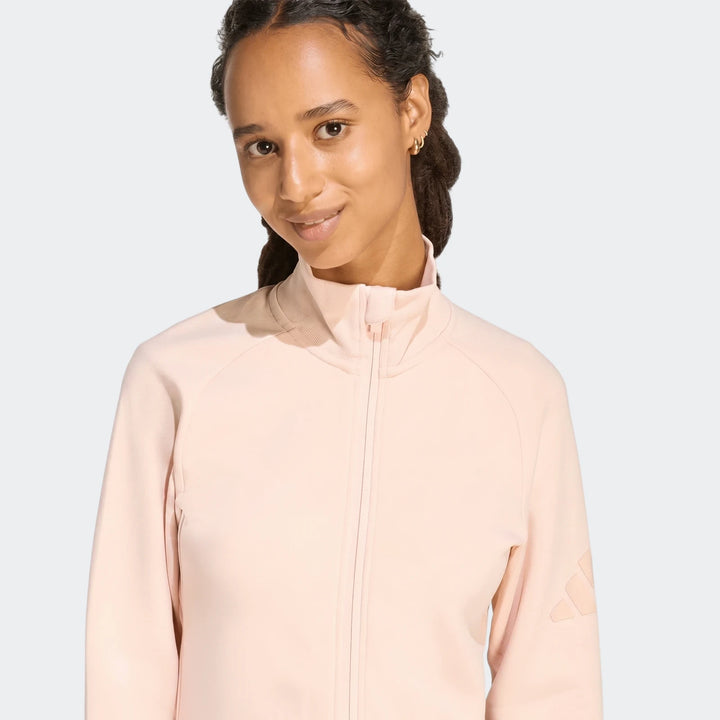 Woman smiling in a light pink Soft Luxe Slim Track Top, featuring a high collar and raglan sleeves, shown from the waist up.