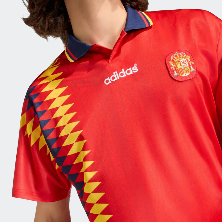 Spain 1994 Retro Home Jersey on a model, showcasing the red design with patterned sleeve and national crest.