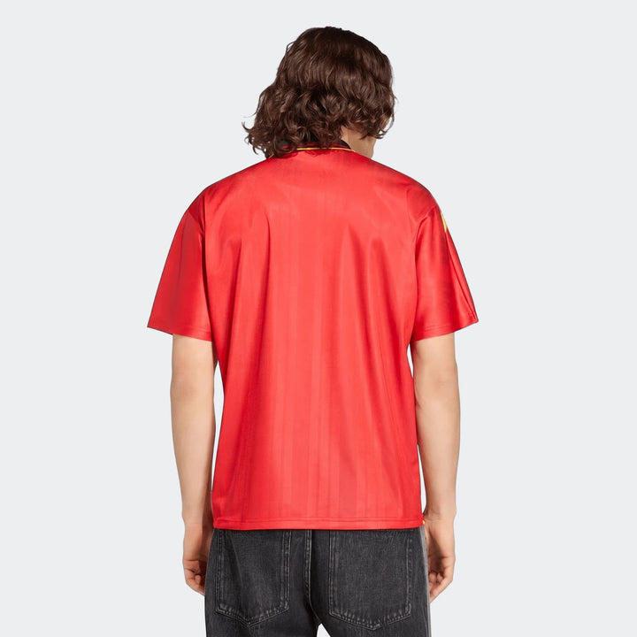 Back view of a male model wearing the Spain 1994 Retro Home Jersey, a red short-sleeve football shirt with curly brown hair