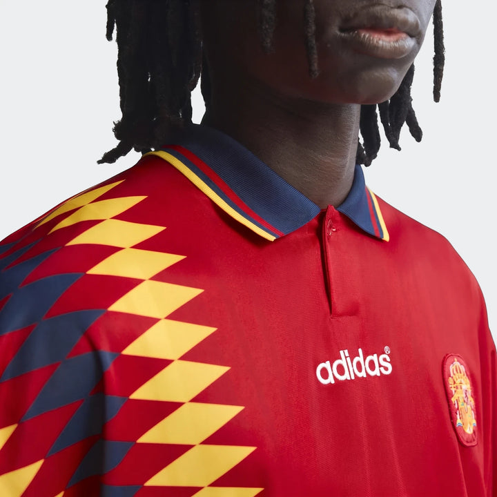 Close-up of a model wearing the Spain 1994 Retro Home Jersey, featuring a red base with yellow and blue diamond patterns and