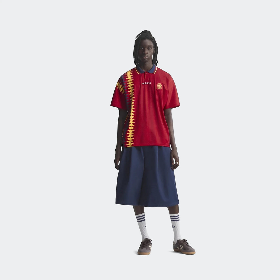 Spain 1994 Retro Home Jersey in red with yellow geometric side panel, short sleeves and navy collar, front view.