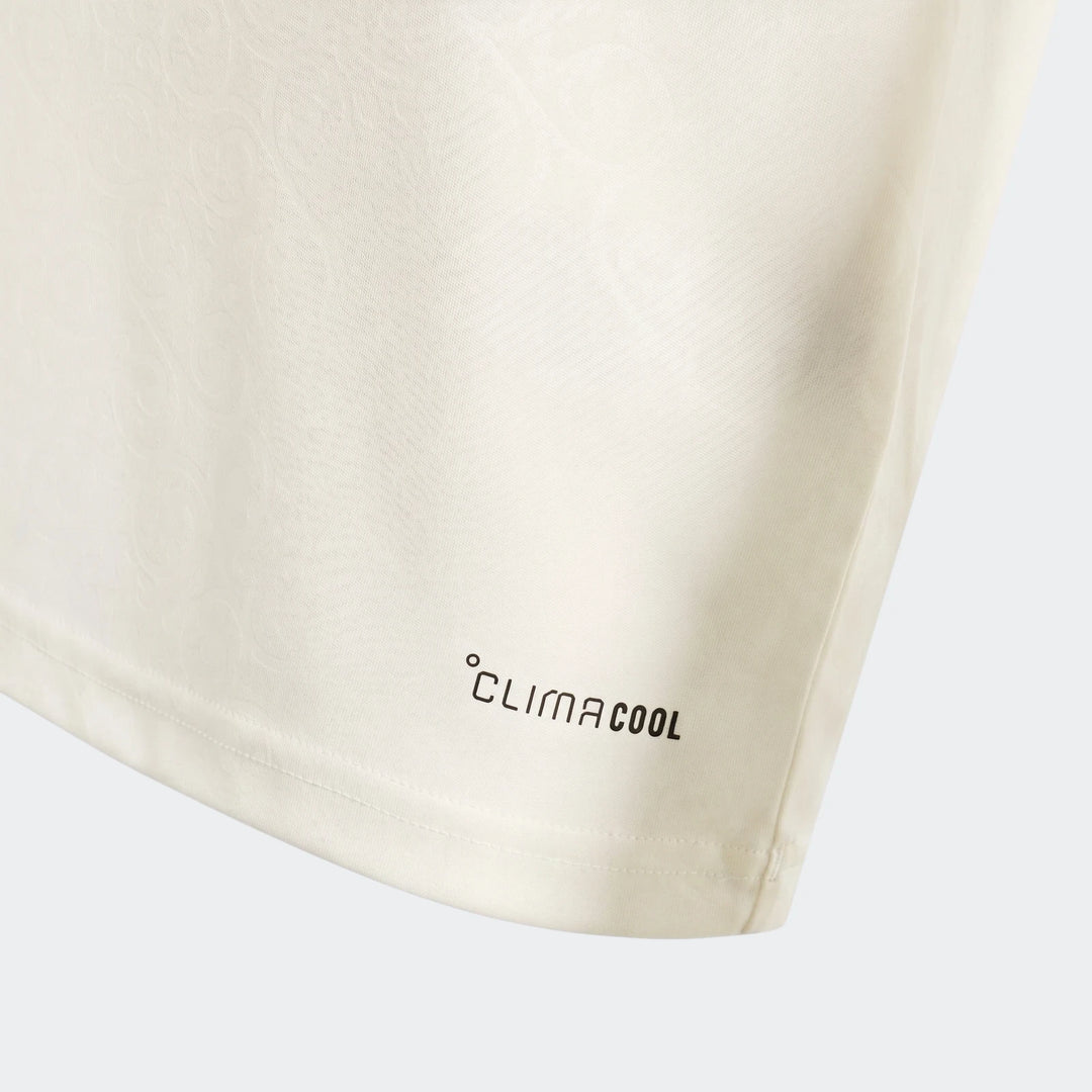 Cream Spain 25/26 Away Youth Jersey close-up, showing subtle fabric pattern, black Climacool logo, and hem stitching detail.