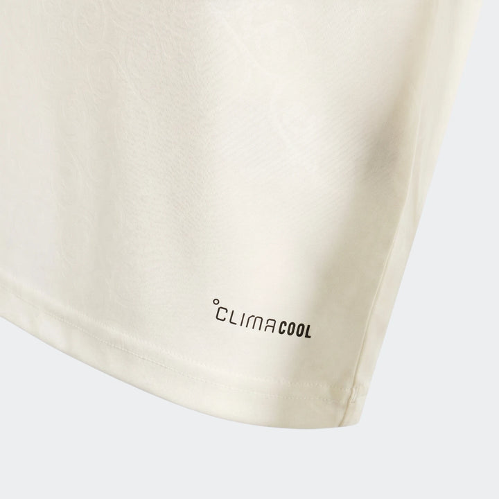 Cream Spain 25/26 Away Youth Jersey close-up, showing subtle fabric pattern, black Climacool logo, and hem stitching detail.