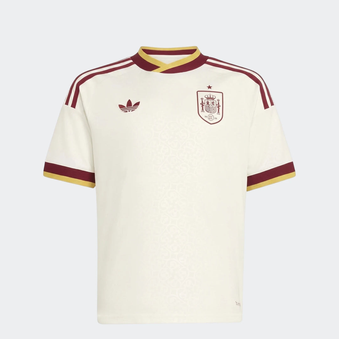Spain 25/26 Away Youth Jersey, an off-white short-sleeve football shirt with maroon and yellow details, shown front view.