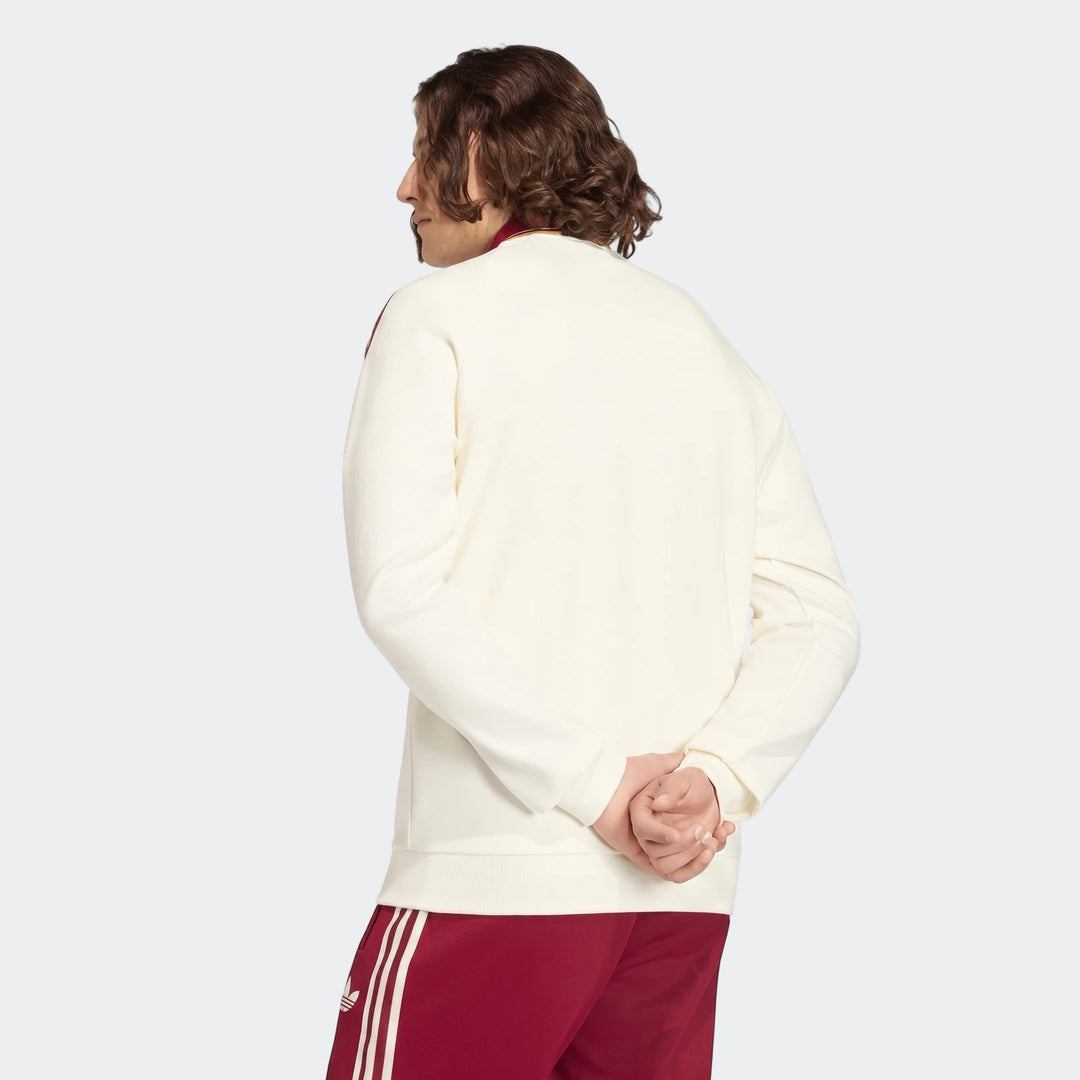 Spain Away Anthem Jacket in off-white with red details, worn by a male model from the back, hands clasped.