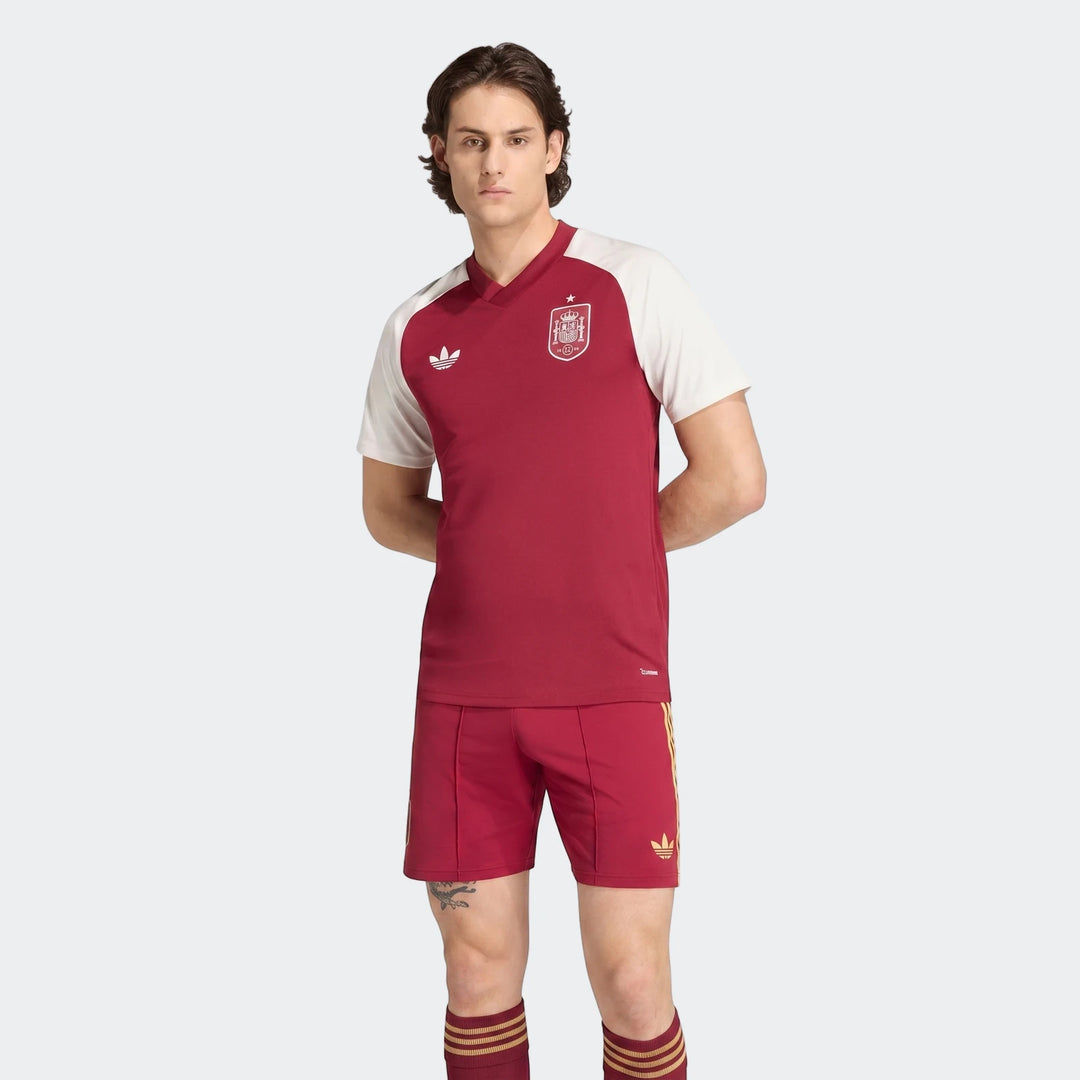 Male model wearing a red and white Adidas Spain Away Pre-Match Shirt and matching red shorts, front view.