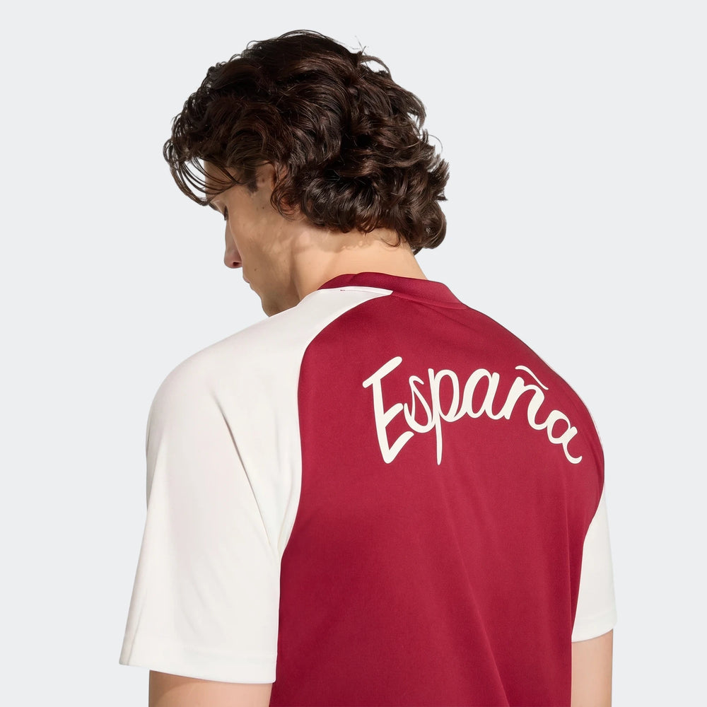 A man models the Spain Away Pre-Match Shirt, featuring red and white colors, viewed from the back, showcasing the 'España'
