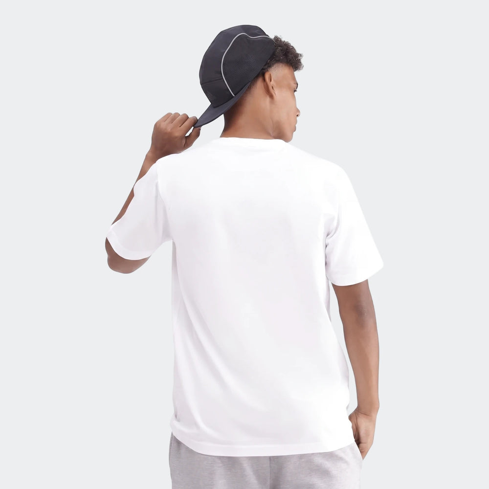 Young person wearing a white Sportswear Badge Of Sport T-Shirt and dark cap, viewed from the back.