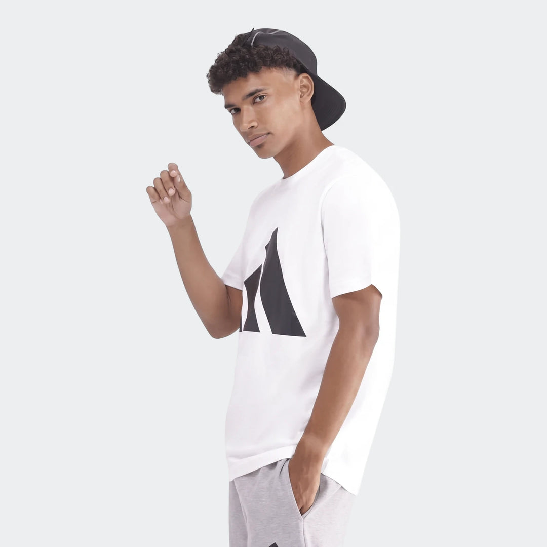Sportswear Badge Of Sport T-Shirt worn by a male model, white with a black logo, paired with grey sweatpants.