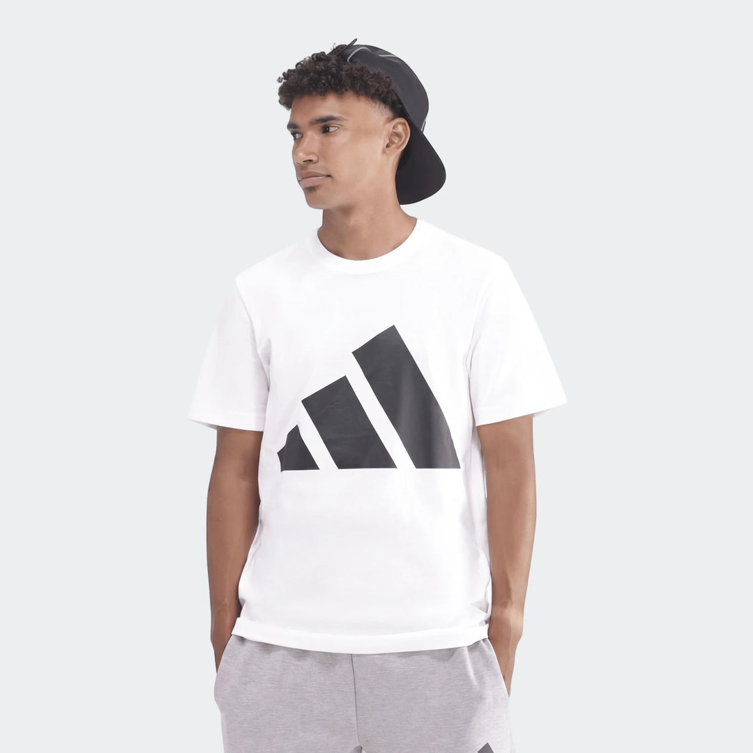 Male model wearing a white Sportswear Badge Of Sport T-Shirt with a black logo, shown from the waist up.