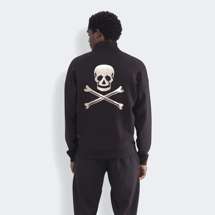 Back view of a man wearing a black Sportswear Open Hem Future Icons Half-Zip Sweatshirt with a metallic skull and crossbones