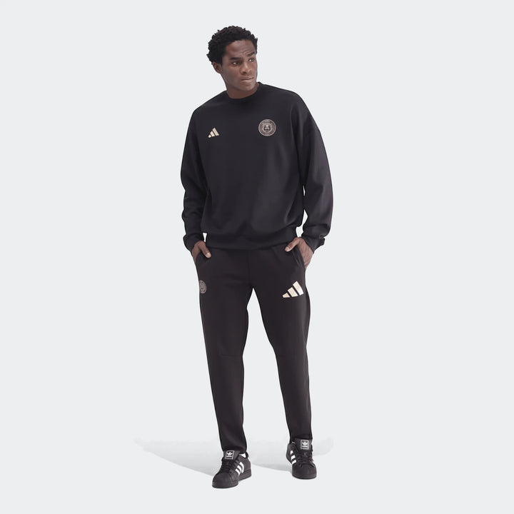 Male model in a black Sportswear Open Hem Future Icons 3-Bar Crew Sweatshirt, matching black sweatpants, and sneakers.