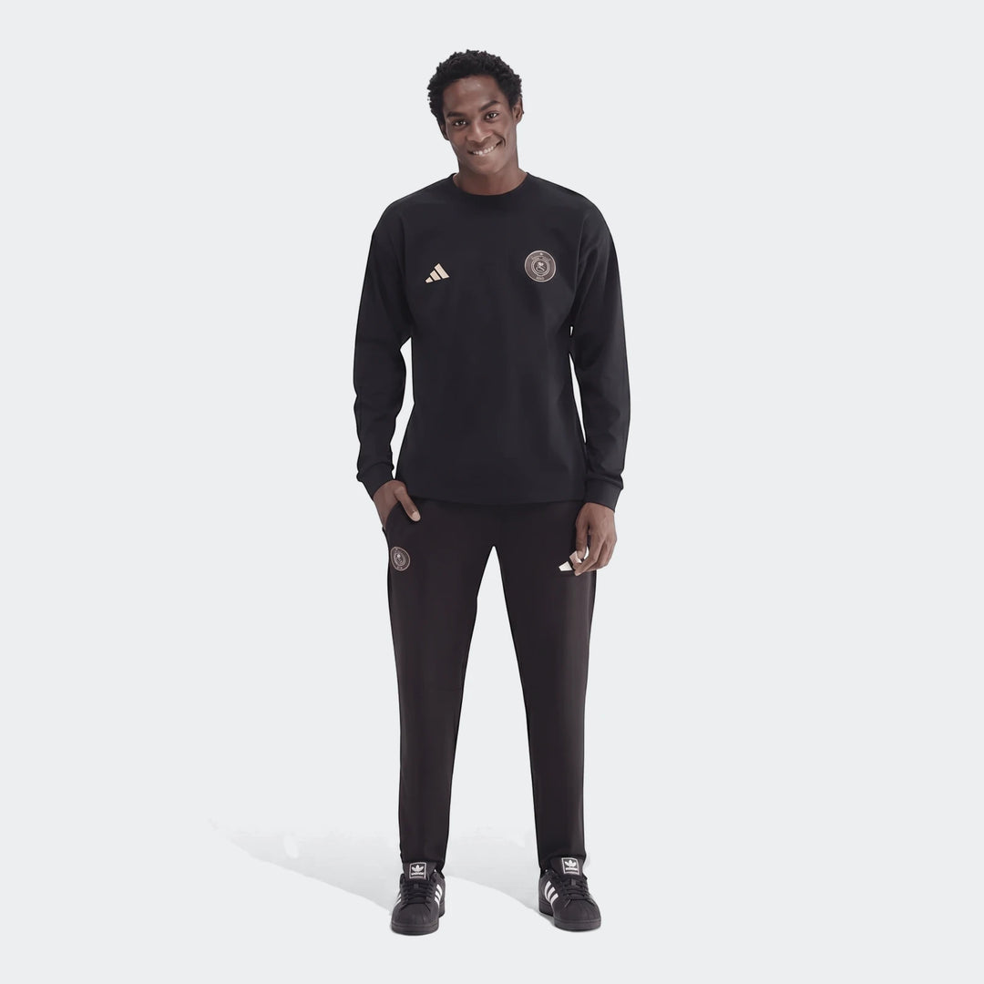 Men's black Sportswear Open Hem Essentials+ Slim Long Sleeve T-Shirt and track pants on a model, full view.
