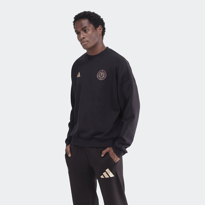 Male model wearing a black Sportswear Open Hem Future Icons 3-Bar Crew Sweatshirt and matching sweatpants with gold logos,