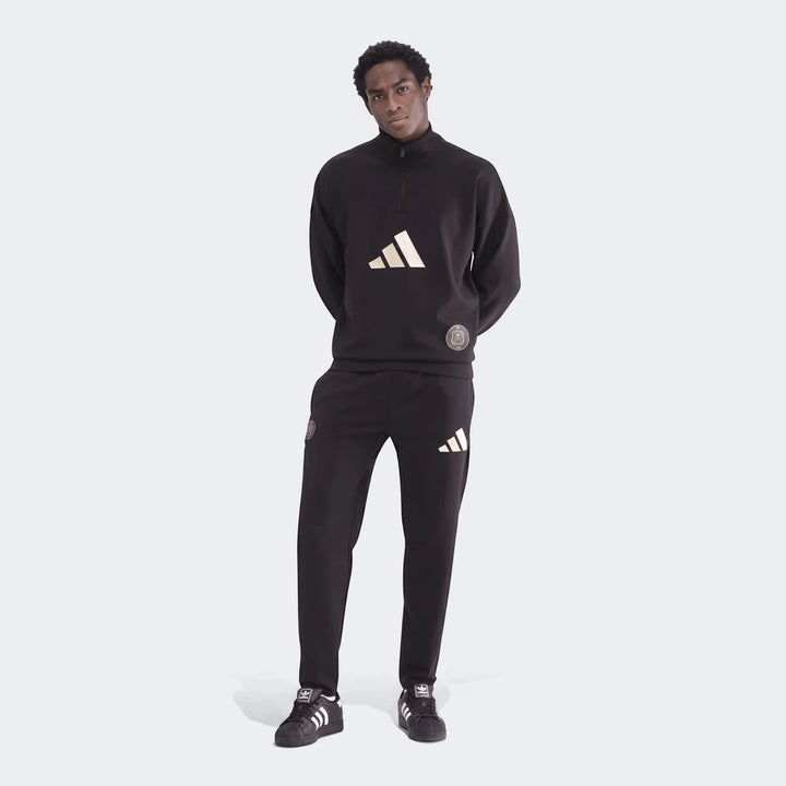 Male model wearing a black Adidas Sportswear Open Hem Future Icons 3-Bar Half-Zip Sweatshirt and matching track pants, full